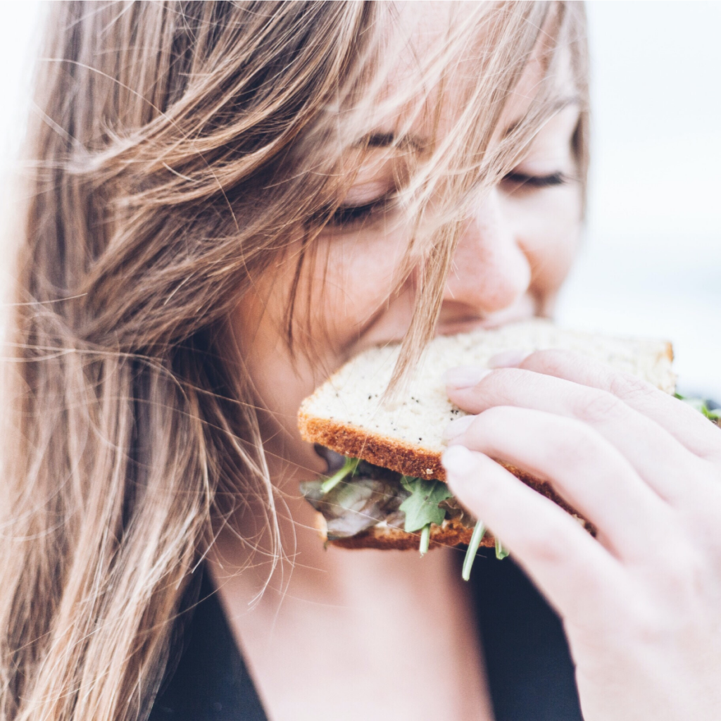 femme dégustant un sandwich